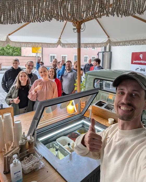 Selfie vom apeice-Team an der Eisvitrine, dahinter warten Gäste